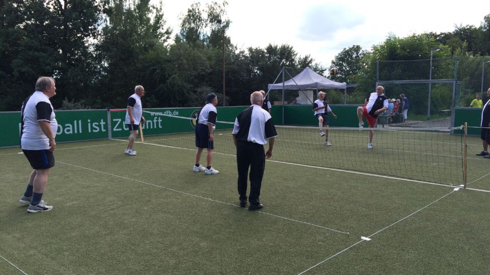 Mehrere ältere Männer spielen Volley-Fussball